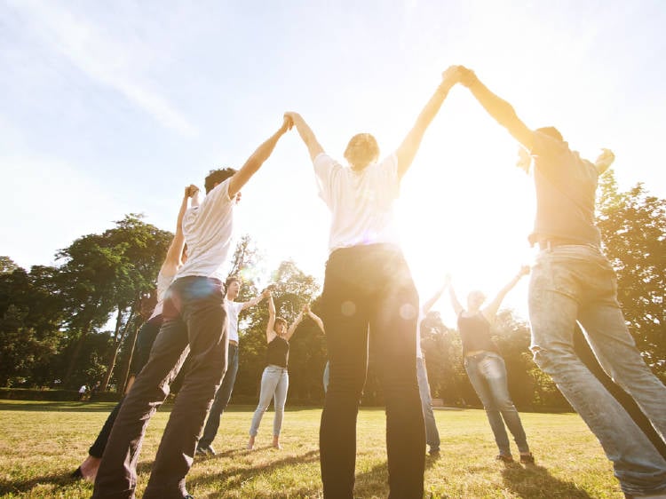 un grupo de personas baila en circulo al aire libre