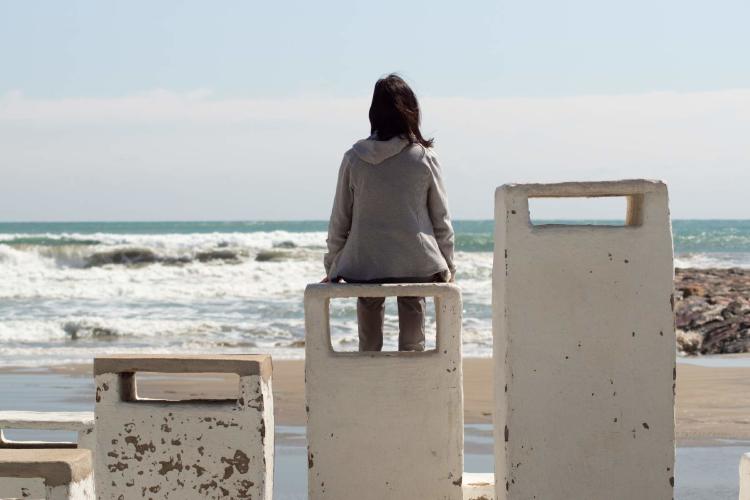 Niña solitaria mirando el mar