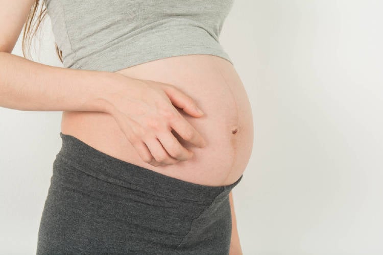 Mujer embarazada rasca su barriga