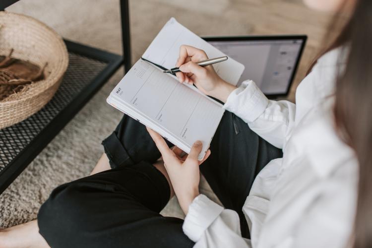 Mujer sentada escribiendo en agenda