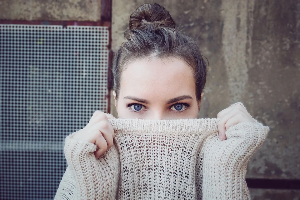 Chica de ojos azules sosteniendo un pullover