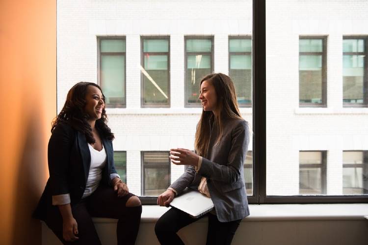 Dos mujeres conversando en una oficina