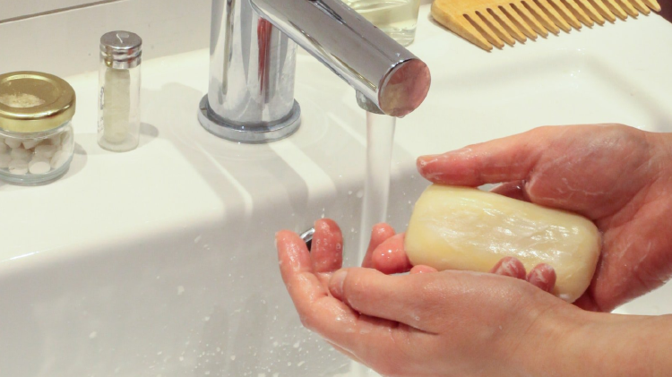 persona lavándose las manos con agua y jabón