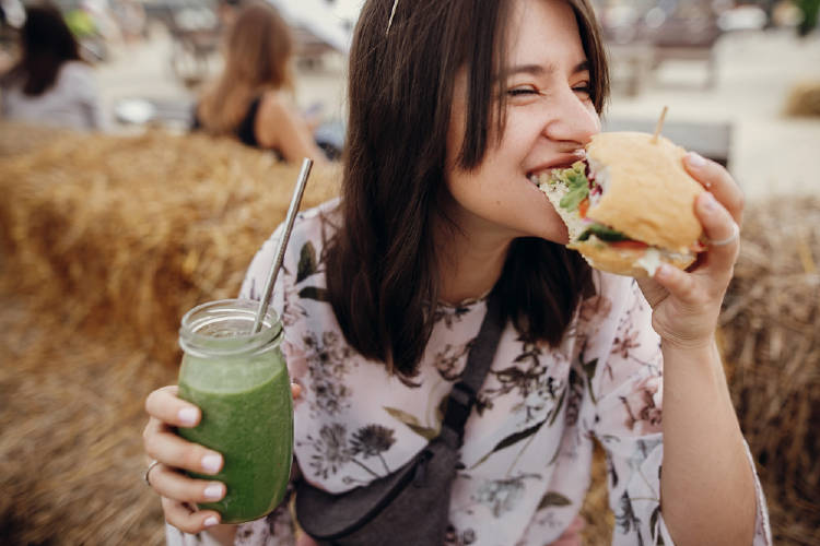 vegana feliz come una hamburguesa y un batido verde