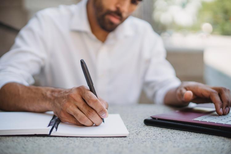 Hombre escribiendo en cuaderno