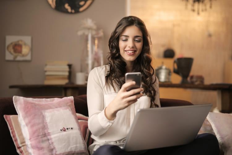 Mujer sonriente sosteniendo teléfono celular