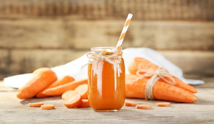 zanahoria batido jugo Jugo de zanahora en un frasco, con otras zanahorias alrededor