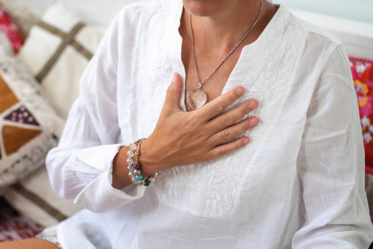mano en el corazon mujer medita con mano en el chakra corazon