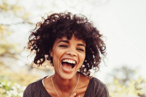Una mujer riéndose en un día soleado