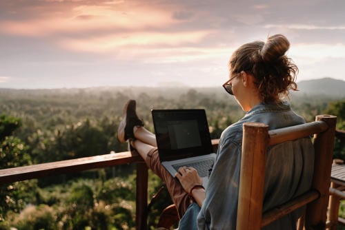 Mujer trabajando en medio de la naturaleza Mujer teletrabajando en medio de la naturaleza