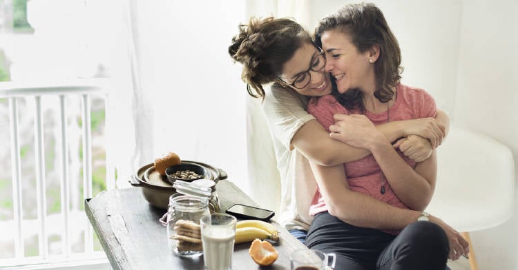 pareja se abraza desayunando