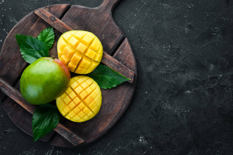 mango Un mango rebanado sobre una tabla de madera