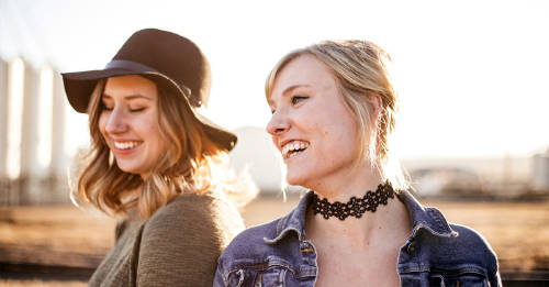 dos amigas fashion riendose y pasando un buen momento al aire libre