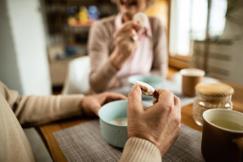 Hiporexia trastorno de la alimentación Dos ancianas tomando el té con galletitas.