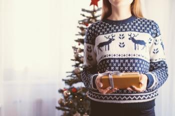 Mujer sosteniendo un regalo de navidad