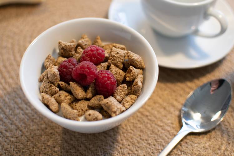 cereal desayuno Cereales en un recepiente junto a una taza de café