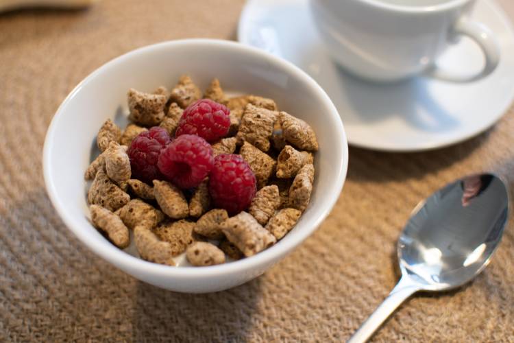 Cereales en un recepiente junto a una taza de café