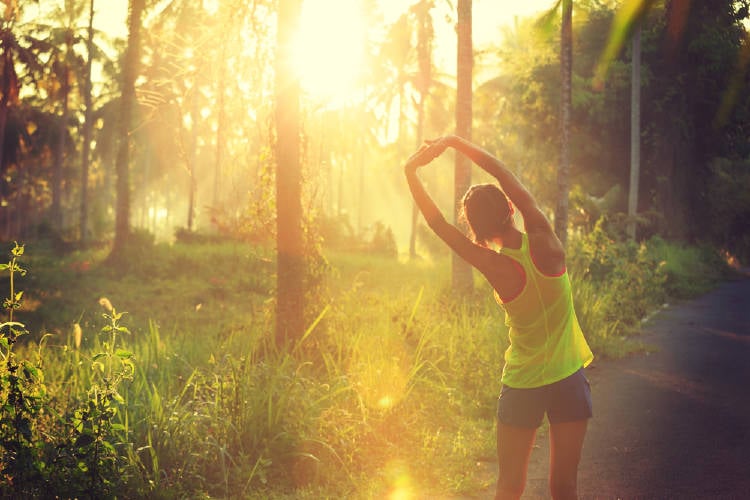 mujer entrena al amanecer en la naturaleza