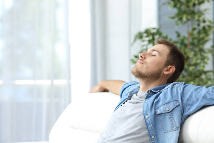 hombre se relaja en un sillon blanco