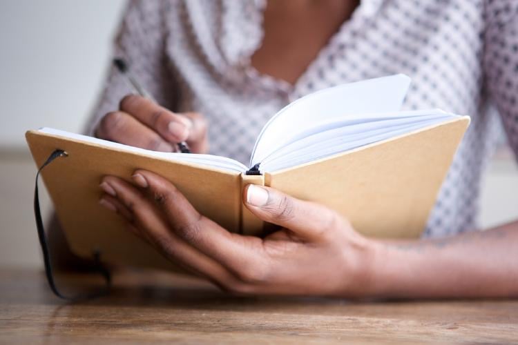 Persona escribiendo en un cuaderno