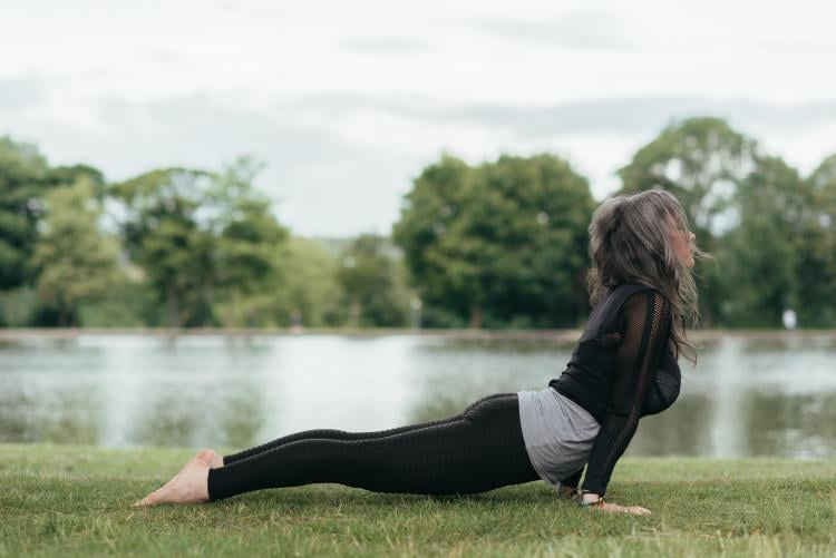 Mujer practicando yoga en el césped