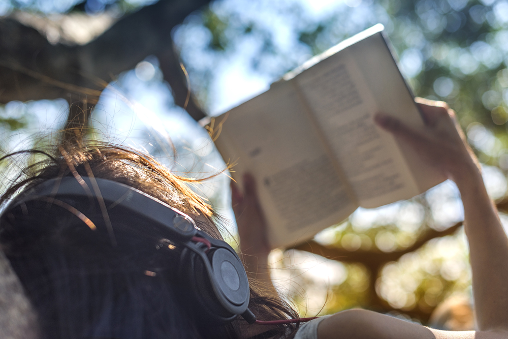 mujer leyendo auriculares mujer leyendo auriculares