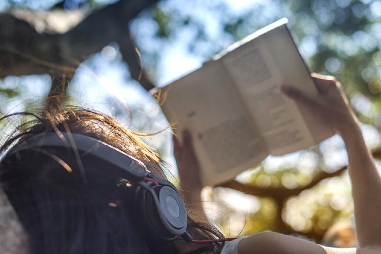 mujer leyendo auriculares