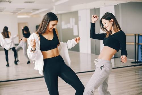 dos hermosas chicas esbeltas haciendo baile gimnasia salon baile_1157 13817