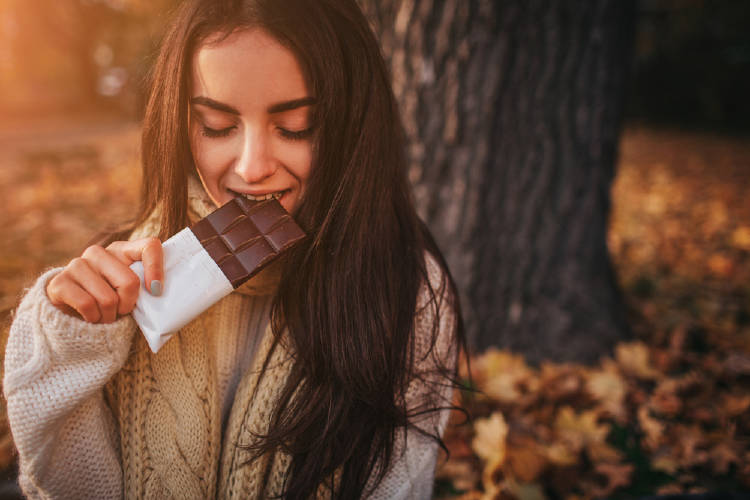 Una mujer comiendo una barra de chocolate