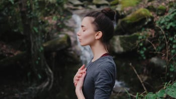 Mujer meditando en bosque
