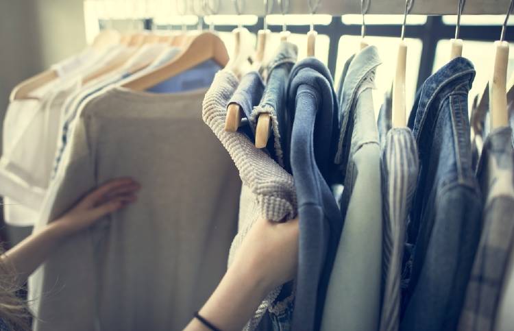 perchero con prendas de ropa, camisas y camperas, en los tonos azules