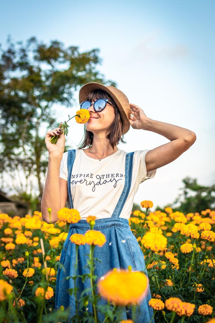 woman holding hat and smelling yellow flower 1832323 (1)