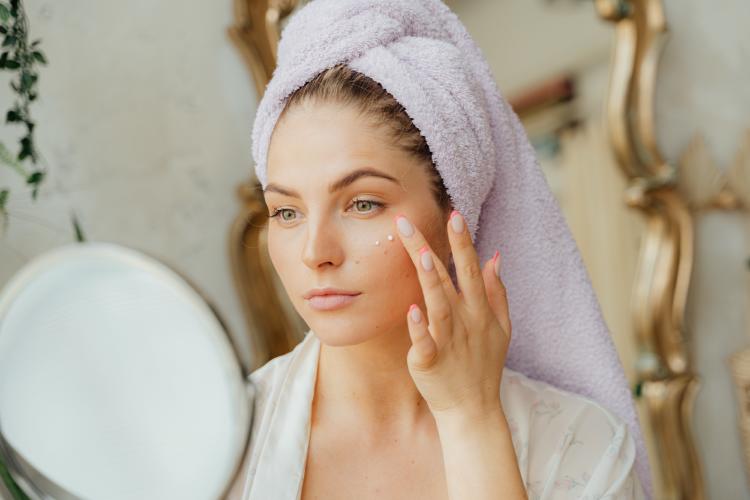 Mujer poniéndose crema en el rostro