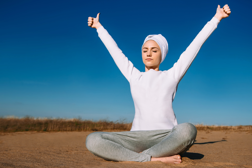 mujer yogui realiza un ejercicio de respiración al aire libre