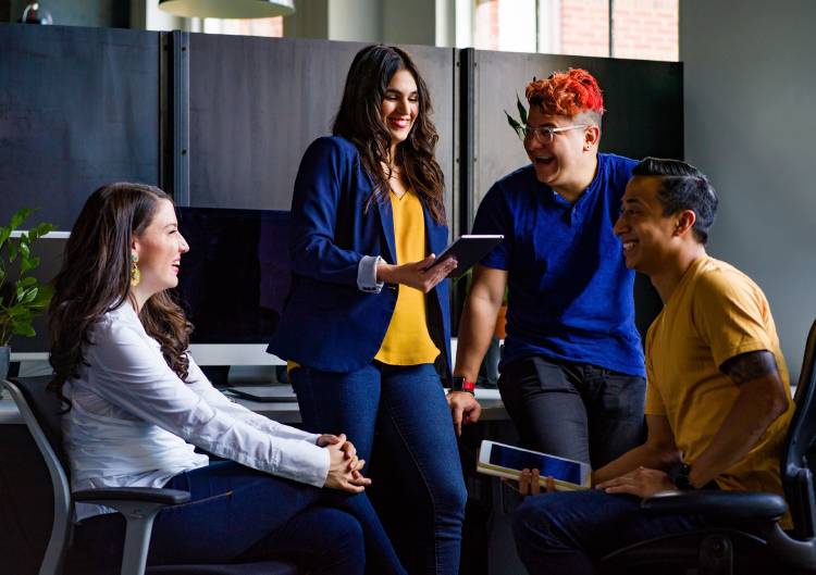 Un grupo de personas conversa divertida en una oficina