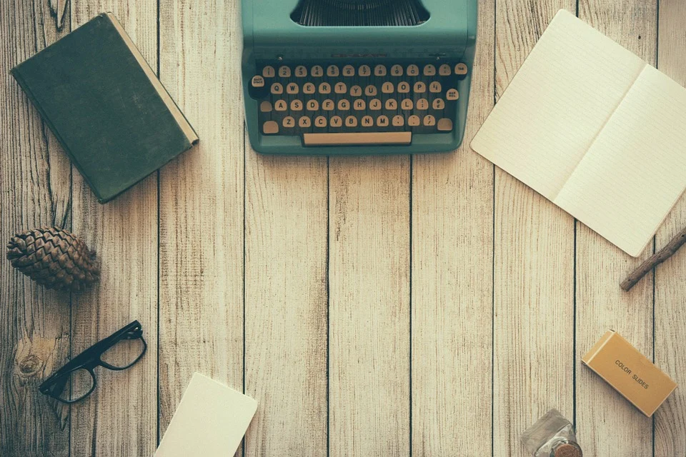 Máquina de escribir, cuadernos y anteojos