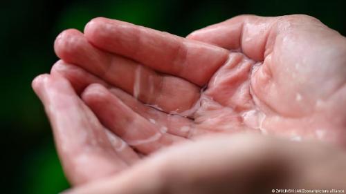 Agua de lluvia contaminada Estas sustaAgua de lluvia contaminada que cae sobre manos.