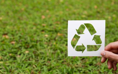 Símbolo del reciclaje sobre pasto