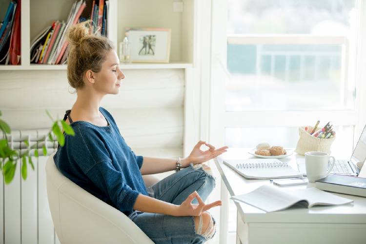 Una mujer meditando en su escritorio