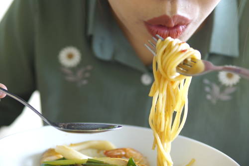 mujer comiendo pasta