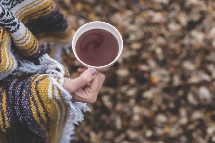 Té hojas frío Una mujer sostiene una taza de té
