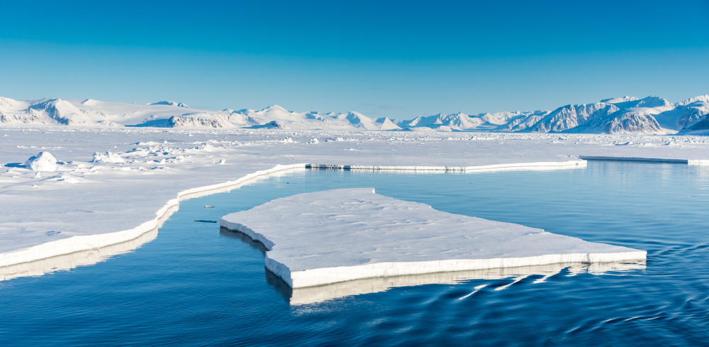 Trozo gigante de hielo flotando en el mar azul Trozo gigante de hielo flotando en el mar azul al lado de un glaciar