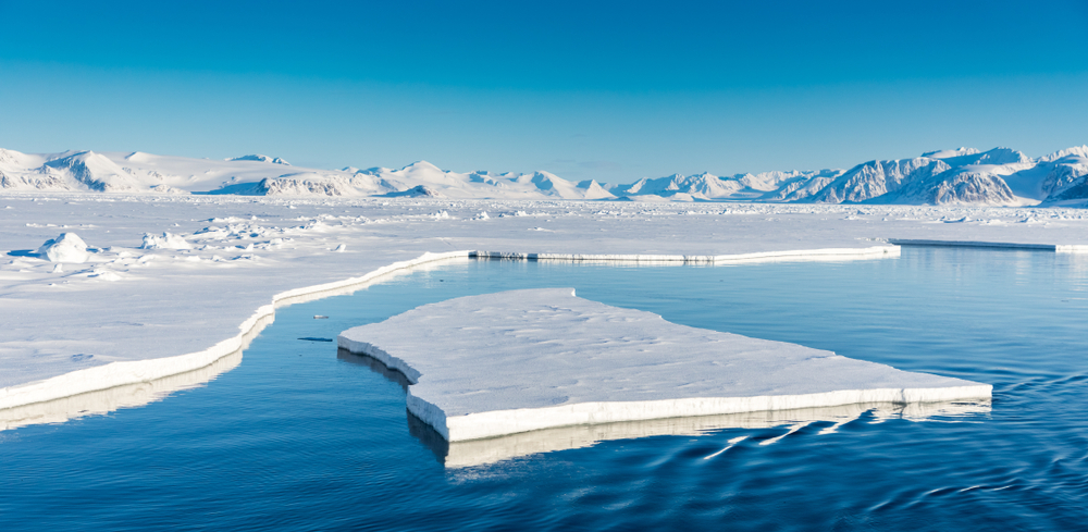 Trozo gigante de hielo flotando en el mar azul al lado de un glaciar 