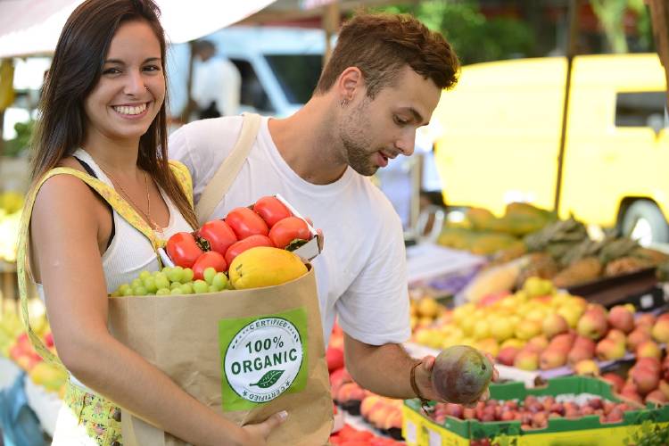 Dos jóvenes compran orgánico en una feria