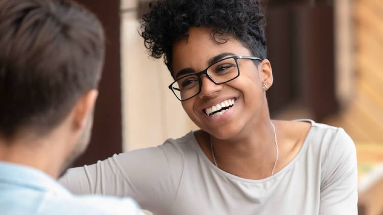 mujer negra con lentes sonrie