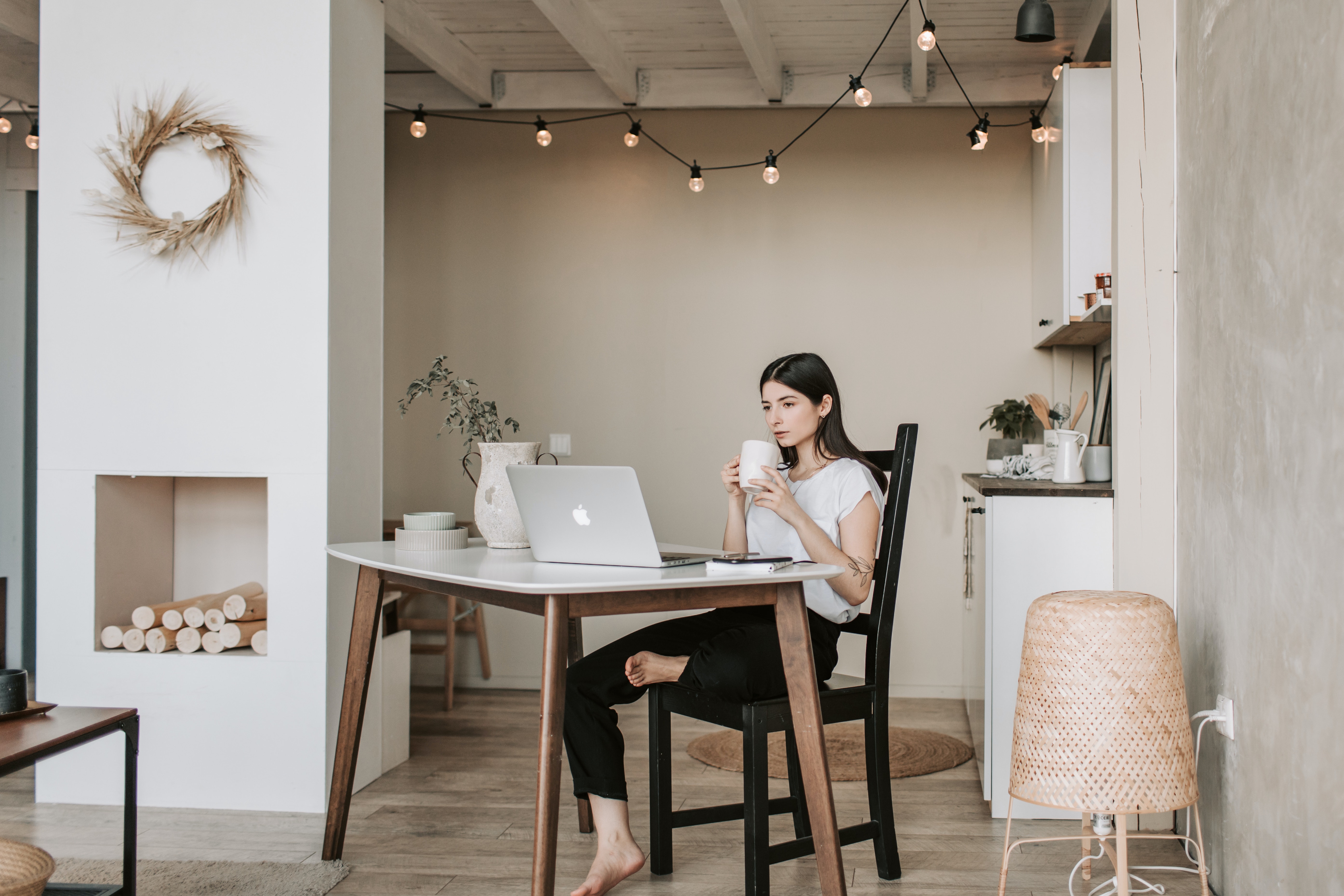 Mujer sentada bebiendo café en una sala con ambiente minimalista