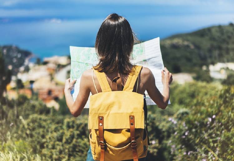 mujer joven viajando sosteniendo mapa