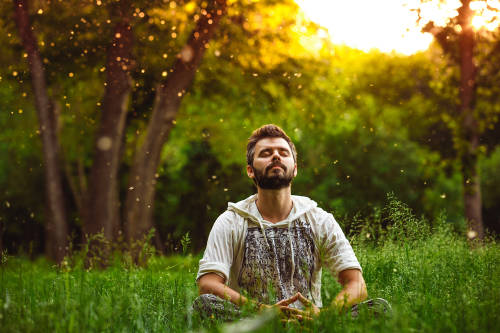 hombre medita al aire libre