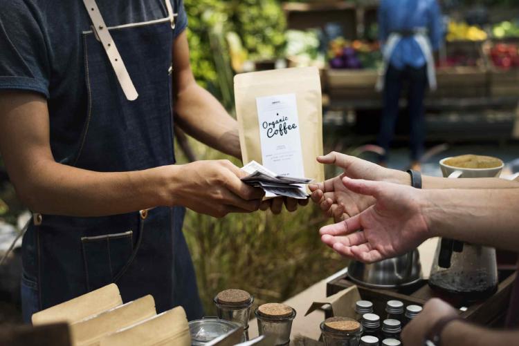 Un feriante vendiendo café orgánico en la calle