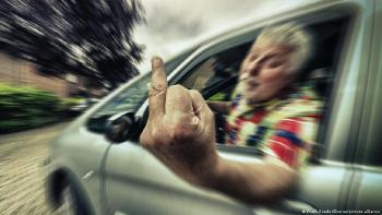 Conductor de un auto haciendo señas ofensivas por la ventanilla
